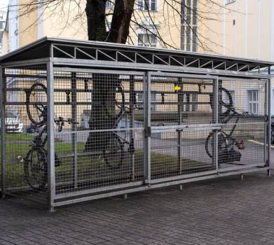Outdoor wire mesh storage container for bicycles near office building