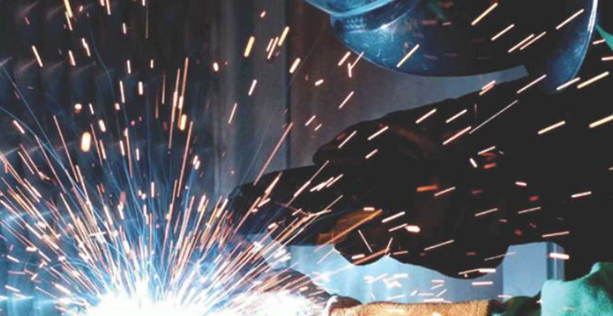 Close-up of MIG welding arc producing bright sparks during metal fabrication