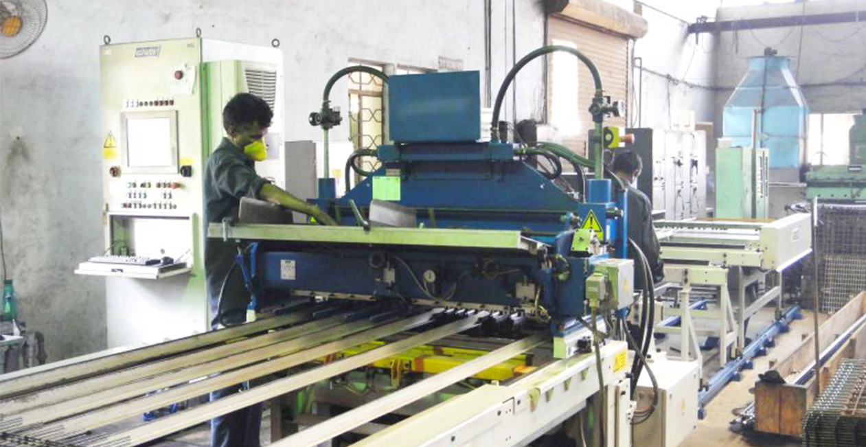 Technician operating advanced CNC spot welding setup for metal fabrication